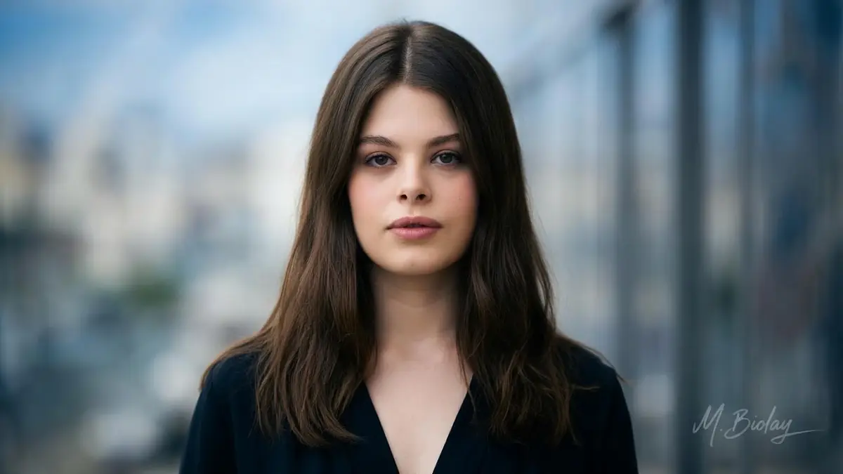 Anna Biolay fixe l'objectif dans ce portrait en gros plan sur fond urbain flou