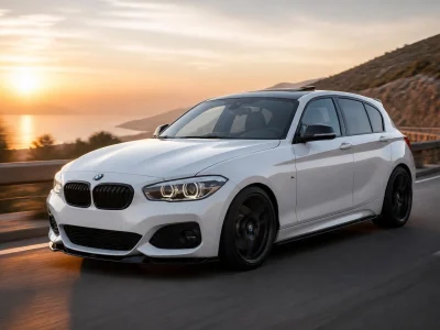 Une M140i blanche roule sur une route côtière au coucher du soleil