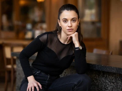 Portrait de la comédienne Camille Genau posant avec élégance dans un décor intérieur sombre