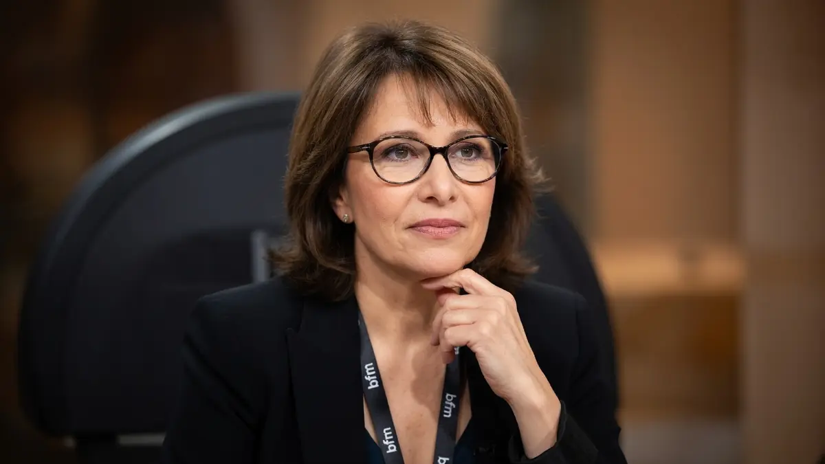 Carole Rousseau pose avec sa main sur le menton dans un studio de télévision
