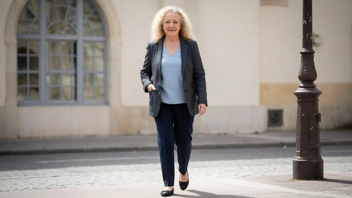 Catherine Hiegel se promène dans une rue pavée près d'un lampadaire