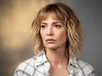 Portrait de la comédienne française céline Vitcoq avec les cheveux blonds mi-longs devant un fond gris