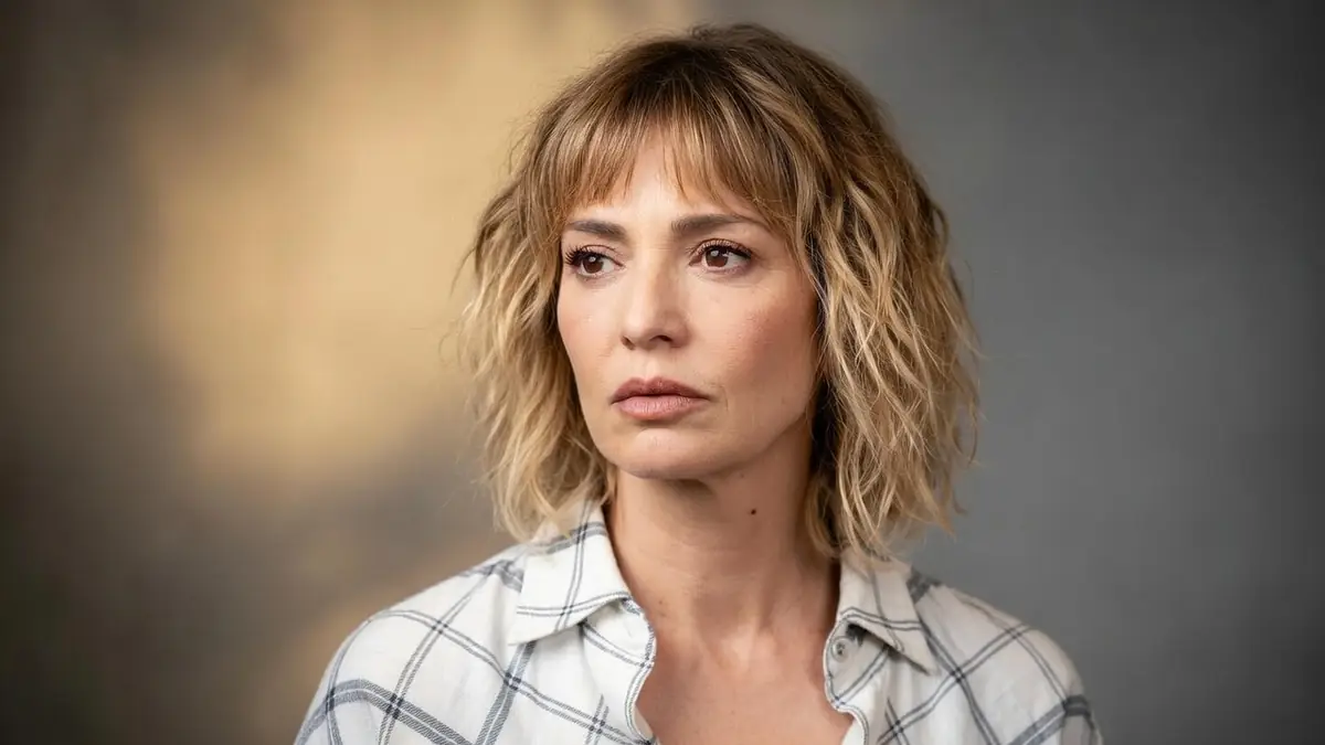 Portrait de la comédienne française céline Vitcoq avec les cheveux blonds mi-longs devant un fond gris