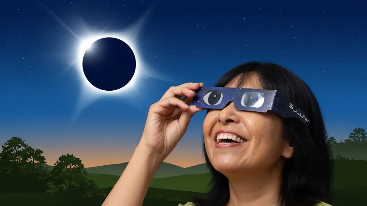 Une femme tient des lunettes éclipse solaire pour observer une éclipse dans le ciel étoilé