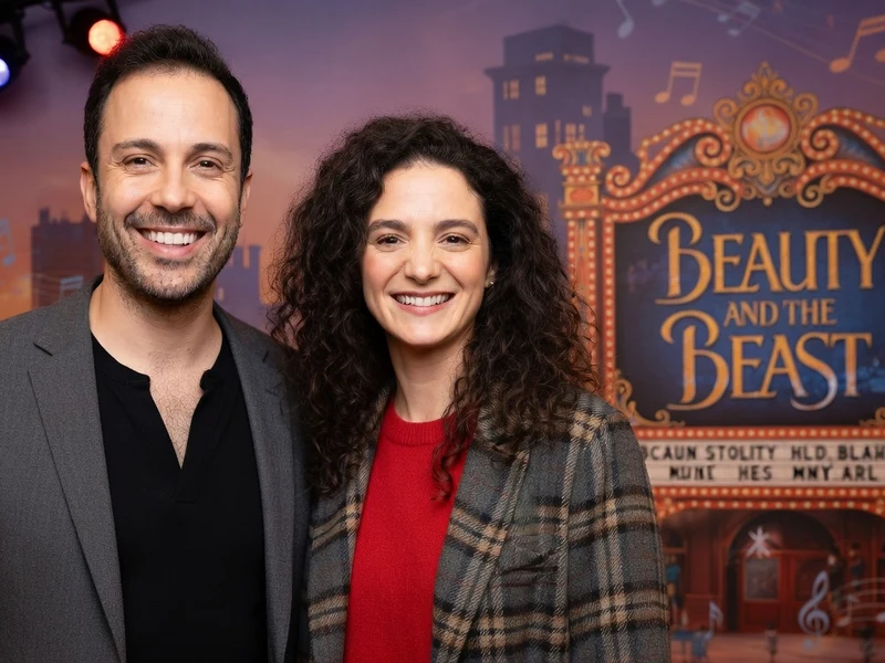 Dan Menasche pose souriant aux côtés d'une femme devant un décor de théâtre
