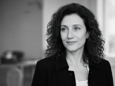 L'image en noir et blanc montre Danièle Arditi aux cheveux bouclés et veste sombre