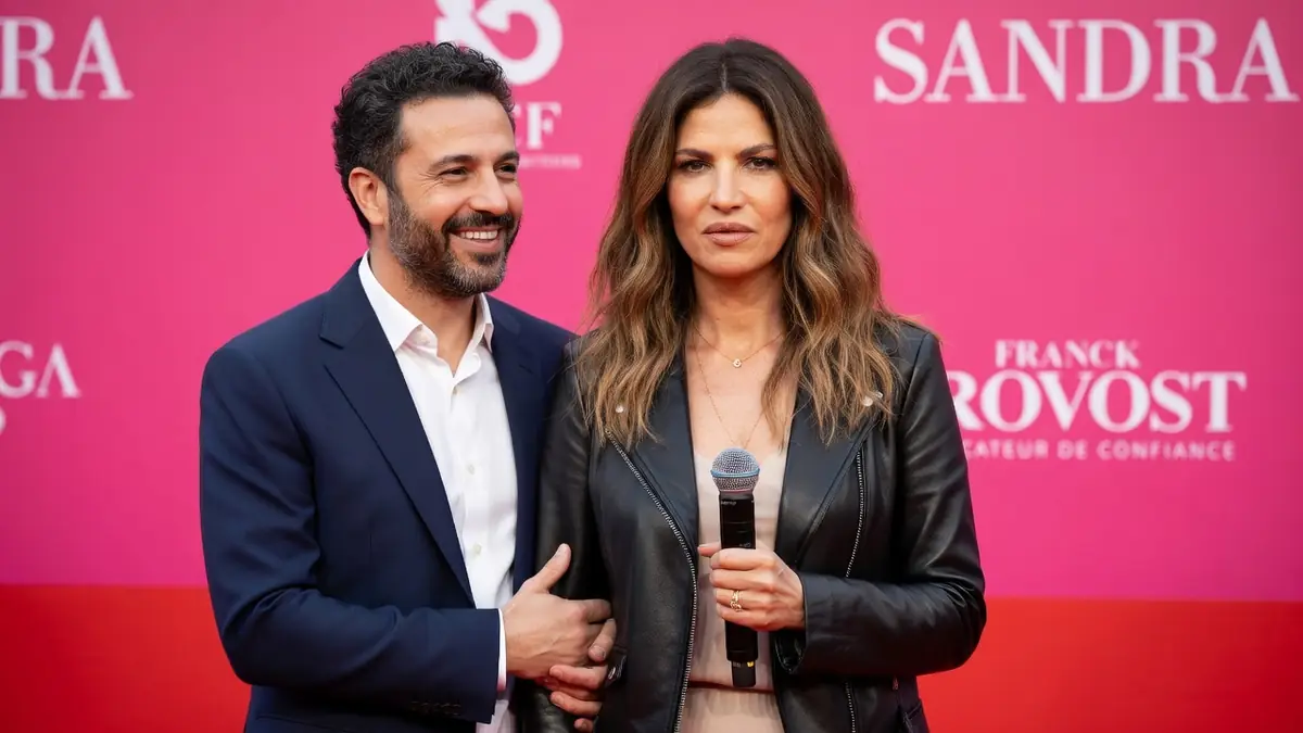 Isabelle Funaro se tient aux côtés d'un homme tout en tenant un microphone