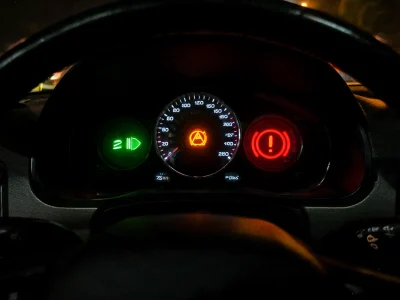 Le tableau de bord montre un voyant sur une voiture allumé derrière le volant la nuit