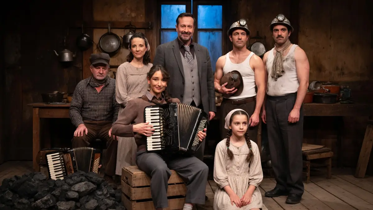 Une famille ouvrière avec du charbon dans les veines pose entourée d'accordéons et de charbon