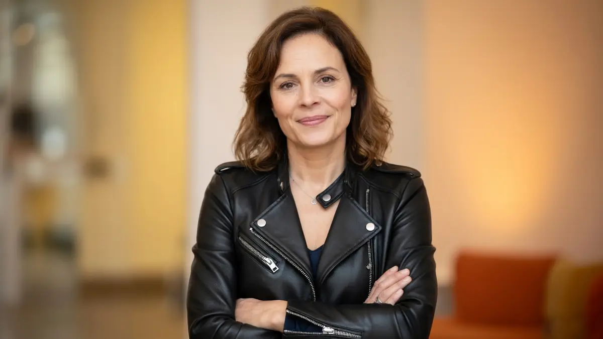 Armelle Deutsch se tient les bras croisés en veste de cuir noire