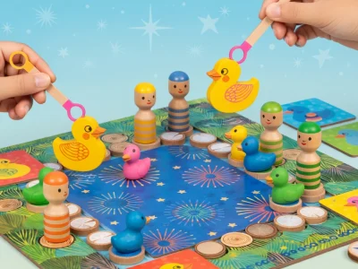 Des mains tiennent des canards au-dessus d'un plateau de Ducky Ducky rempli de figurines en bois