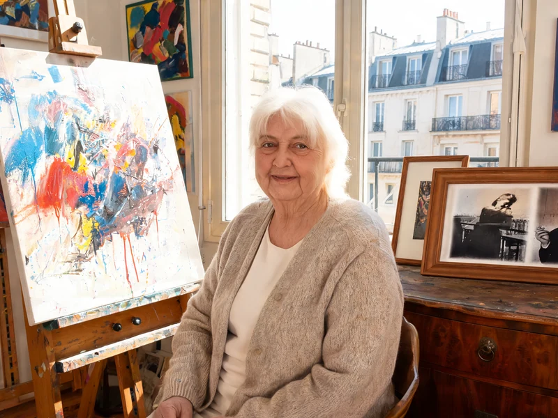 Élisabeth Levitsky assise dans une pièce remplie de peintures abstraites