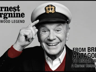 Ernest Borgnine sourit en pointant son index vers sa casquette de capitaine