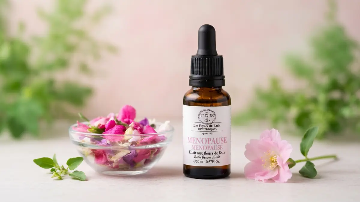 Un flacon d'élixir floral et des fleurs roses illustrent les fleurs de Bach et ménopause