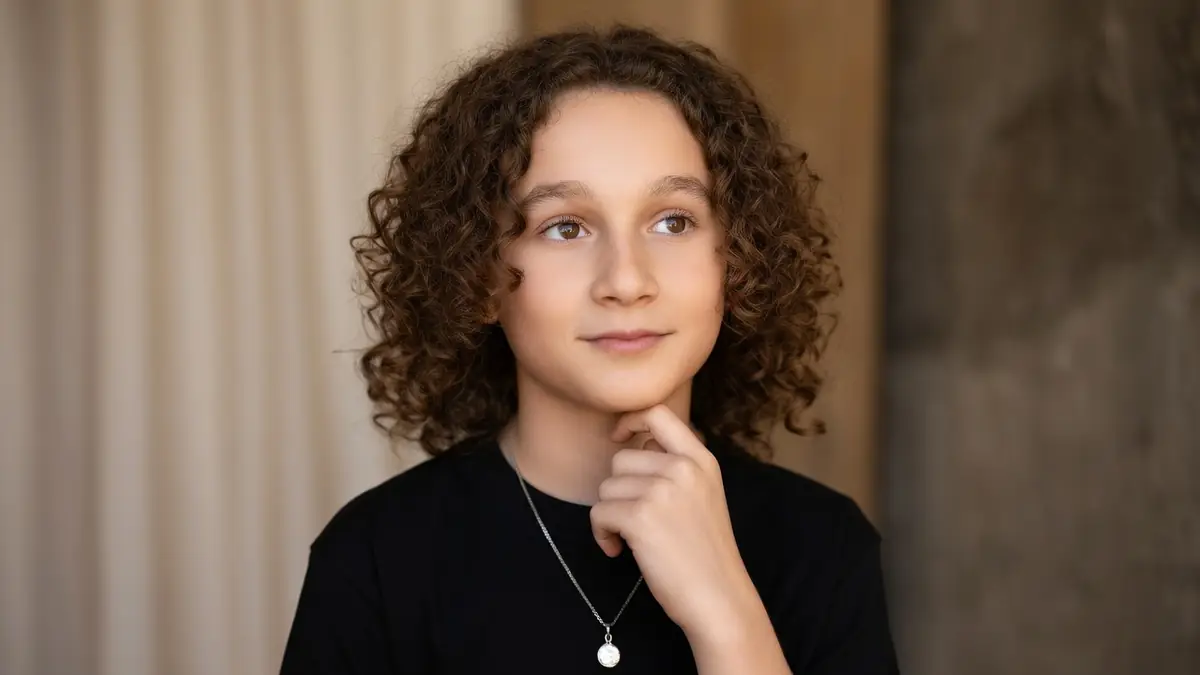 Portrait du jeune acteur Gavril Dartevelle portant un t-shirt noir et un collier pendentif