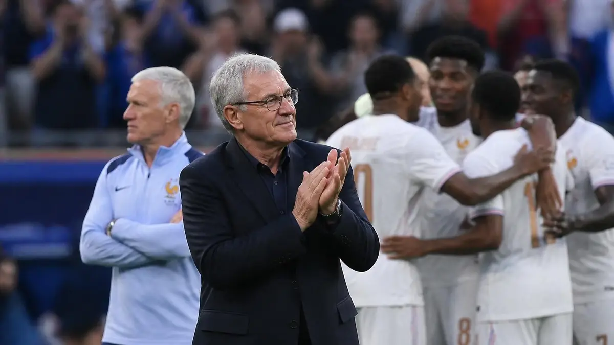 Guy Stéphan applaudit sur le bord du terrain pendant qu'il observe les joueurs de l'équipe de France célébrer un but