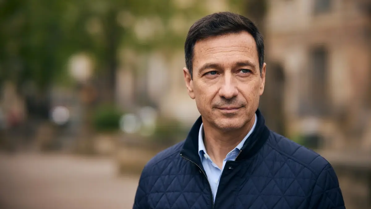 Jean-Marc Michelangeli en veste matelassée bleue sur fond extérieur flou.