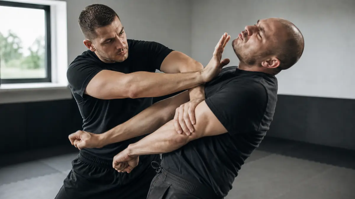 Démonstration de Krav Maga lors d'un entraînement rapproché entre deux hommes.