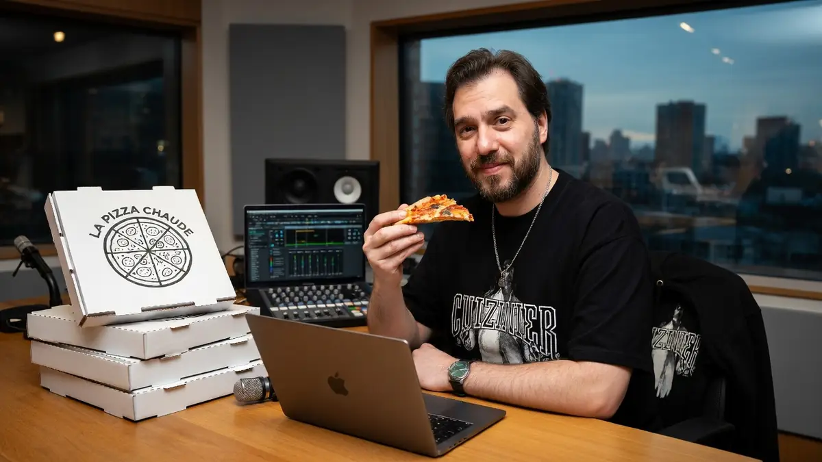 Le cuizinier savoure une part de pizza devant son ordinateur portable