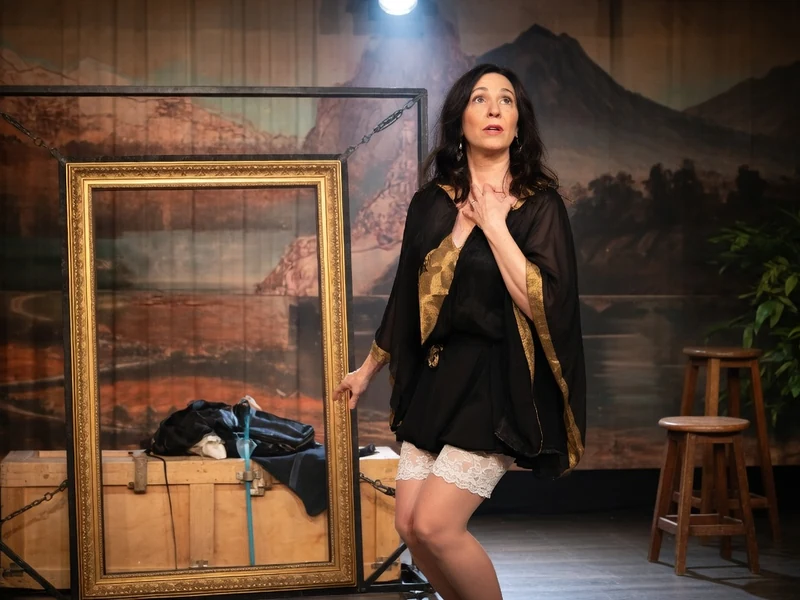Karina Marimon se tient sur scène la main sur la poitrine dans un décor théâtral