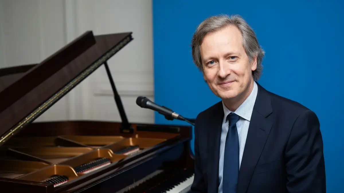 Pierre de Vilno souriant près d'un piano à queue