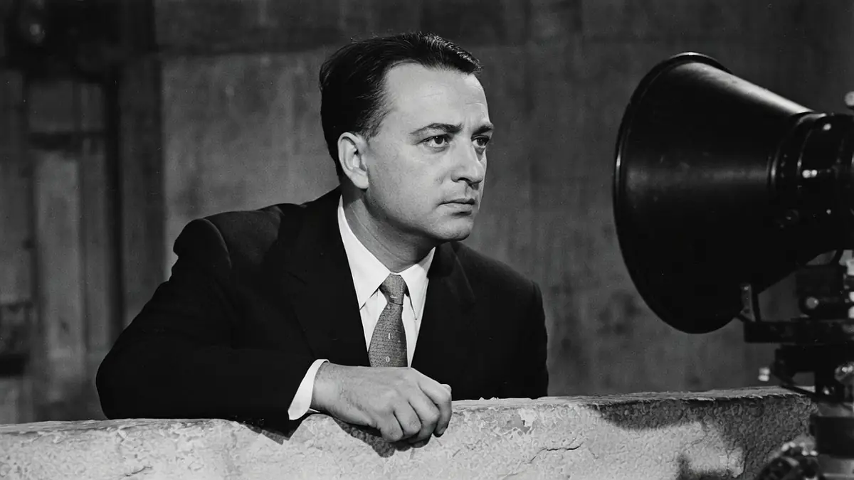 Jacques Tourneur se tient près d'une caméra dans un studio de cinéma