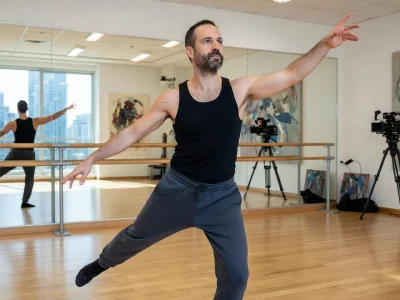 Benjamin Millepied adopte une pose dynamique de danseur dans un studio lumineux avec miroirs et caméras