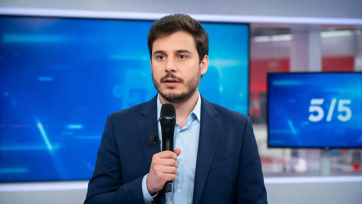 Lorrain Sénéchal tient un microphone dans un studio de télévision