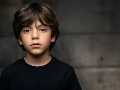 Portrait de l'acteur Noé chabbat posant avec un regard sérieux sur un fond sombre