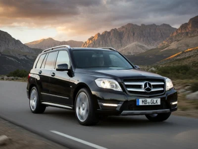 Un glk noir roulant sur une route sinueuse dans un paysage montagneux au coucher du soleil