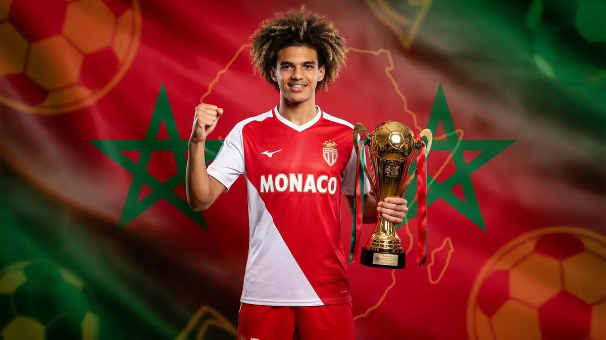 Ilies Belmokhtar lève le poing en tenant un trophée sur fond de drapeau marocain