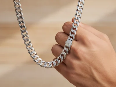 Une main tient une chaînette en argent pour homme aux maillons épais