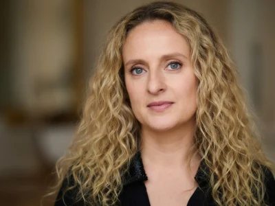 La photo montre aurore Auteuil avec de longs cheveux blonds bouclés