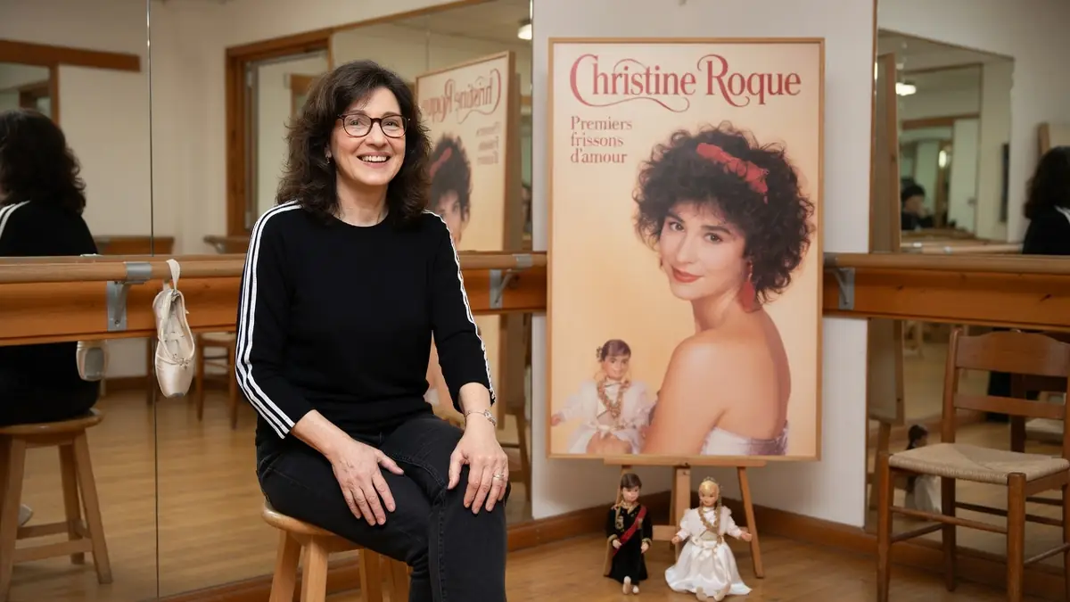 Christine Roque est assise sur un tabouret dans un studio de danse aux miroirs
