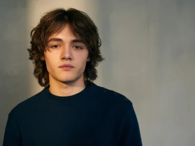 Alexis Rosenstiehl pose en pull bleu marine devant un fond gris