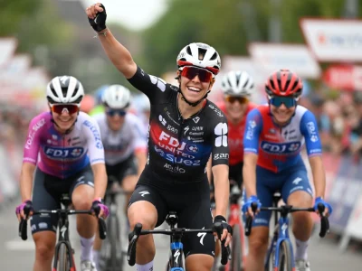 Célia Gery lève le poing en signe de victoire lors d'une course de cyclisme