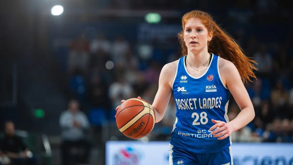 Louise Bussière court sur le parquet en tenant le ballon de basket