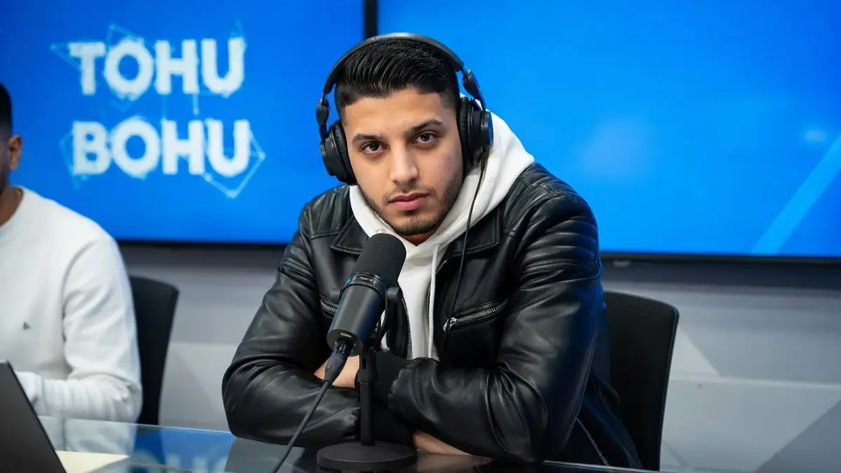 Zifou croise les bras avec un casque dans un studio d'enregistrement