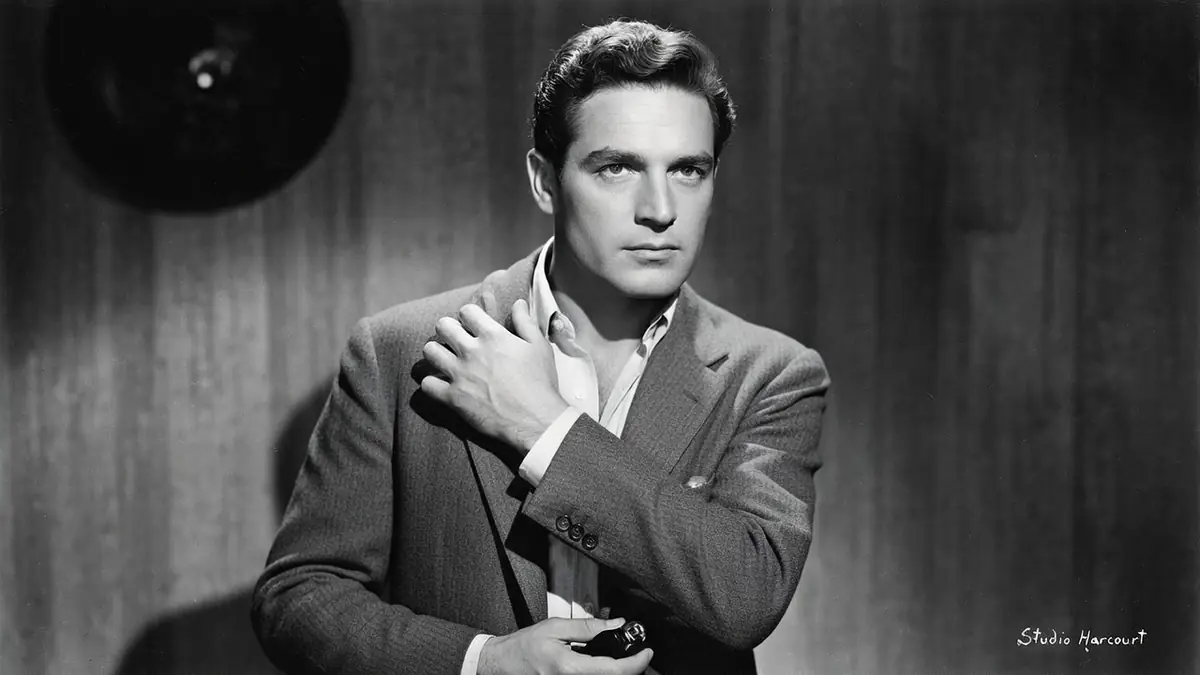 Georges Marchal pose en costume la main sur l'épaule dans ce portrait en noir et blanc
