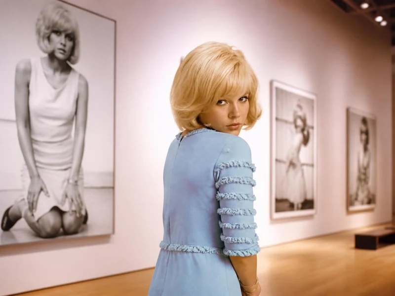Sylvie Vartan regarde par-dessus son épaule dans une galerie exposant ses portraits photographiques