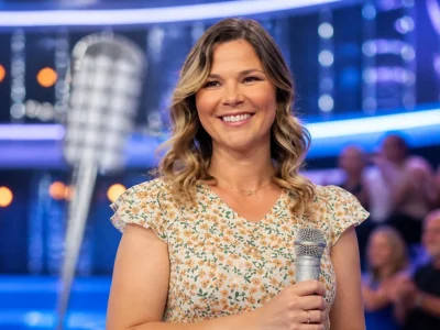 La souriante Virginie N'oubliez pas les paroles sur le plateau de l'émission avec un micro à la main