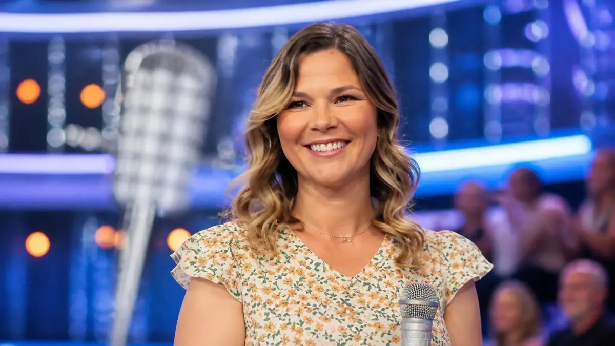La souriante Virginie N'oubliez pas les paroles sur le plateau de l'émission avec un micro à la main