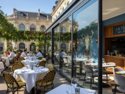 La terrasse ensoleillée du meilleur restaurant à Lyon accueille des clients autour de tables dressées