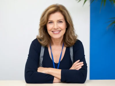 Catherine Alric sourit avec les bras croisés sur ce portrait professionnel