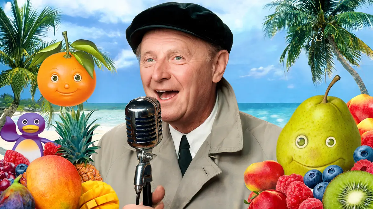 Bourvil chante au micro au milieu de fruits anthropomorphes sur une plage pour illustrer les salades de fruits Bourvil