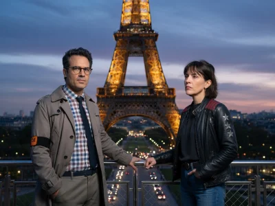 Deux enquêteurs posent devant la Dame de fer pour illustrer le Crime de la Tour Eiffel