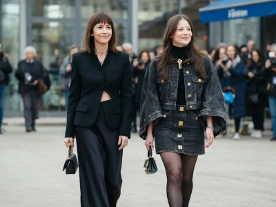 Juliette Lemley marche élégamment aux côtés d'une femme lors d'un événement public entouré de photographes