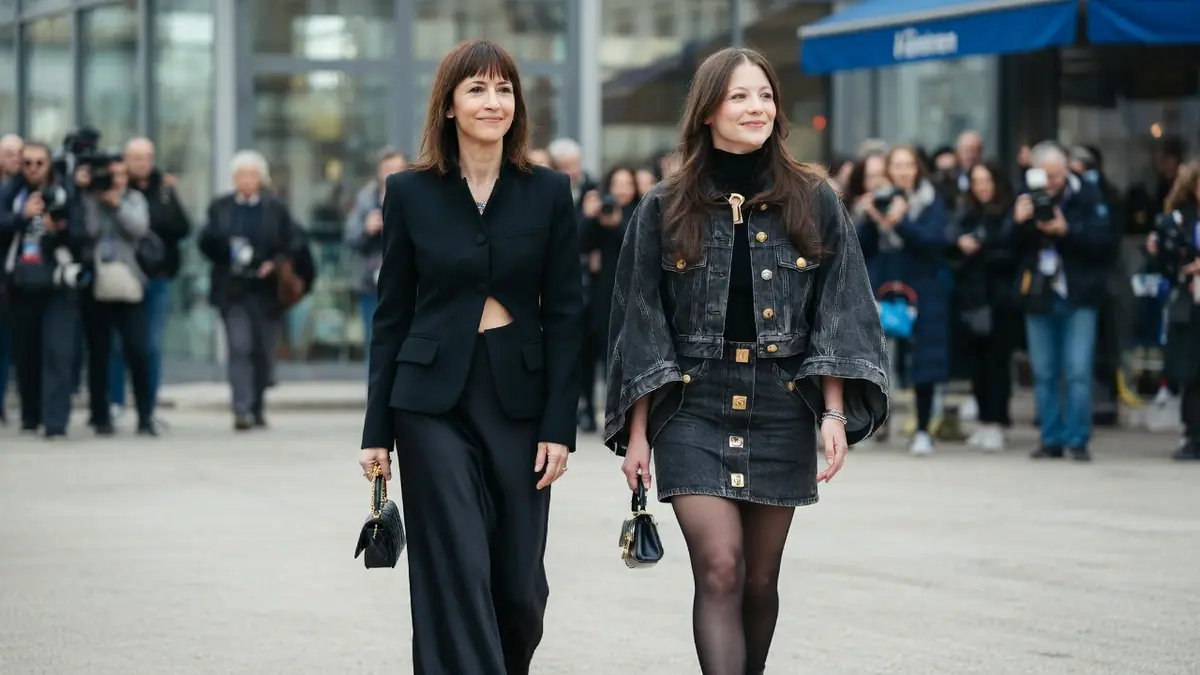 Juliette Lemley marche élégamment aux côtés d'une femme lors d'un événement public entouré de photographes