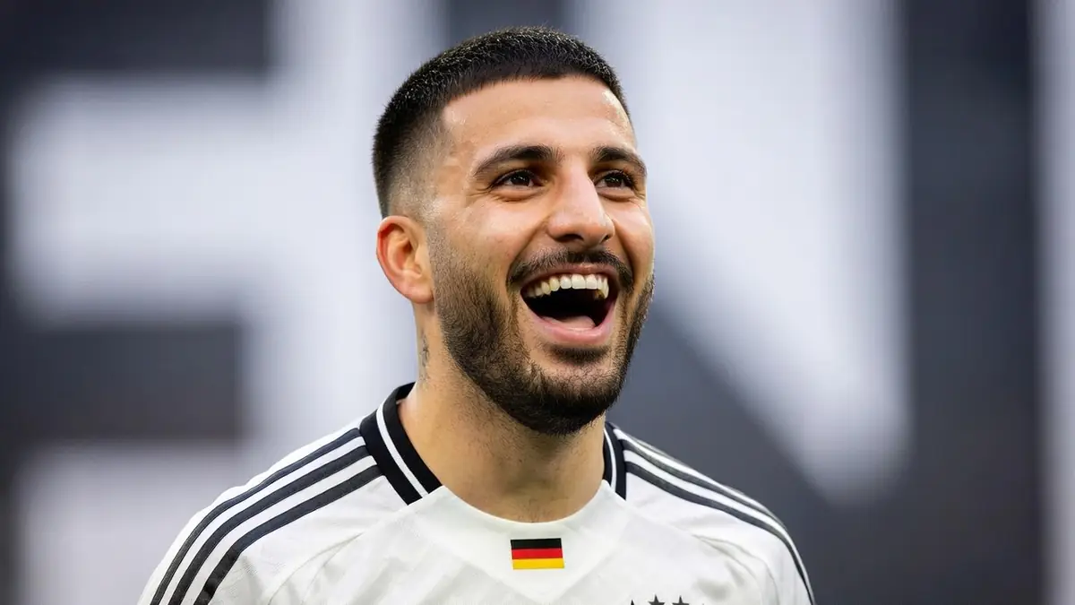 Portrait souriant de Deniz Undav portant le maillot de l'équipe nationale allemande