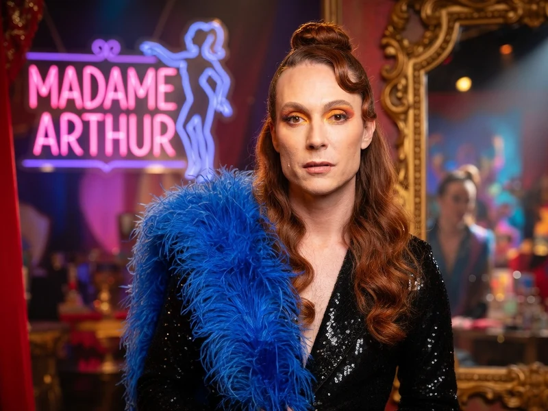Romain Brau arbore un boa bleu et une veste à sequins dans un cadre de cabaret Romain Brau arbore un boa bleu et une veste à sequins dans un cadre de cabaret